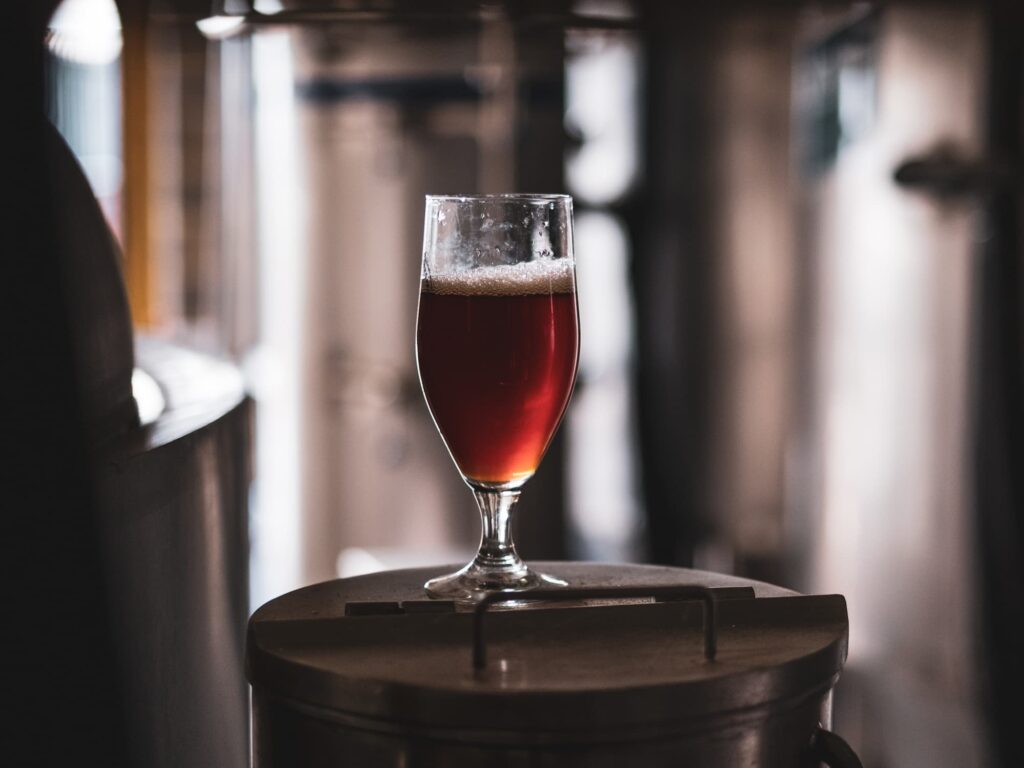 Mørkt glas øl på en lille metal overflade