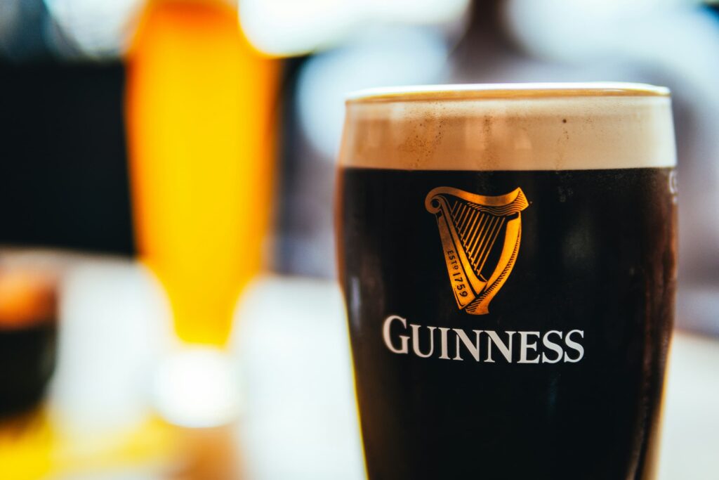 En mørk guinness øl på et bord med en slørret baggrund